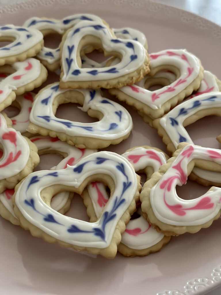 Heart sugar cookies with decorative heart design made with royal icing. 